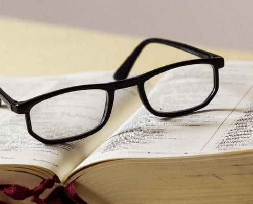 Eine Brille liegt auf einem Fachbuch
